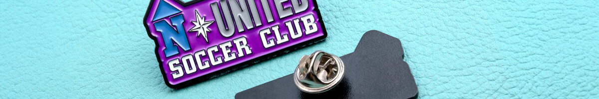 A purple and blue North United Soccer Club pin beside its black backing card and butterfly clutch