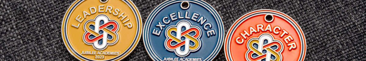 Jubilee Academies Leadership, Excellence and Character award charms in gold, blue and orange enamel