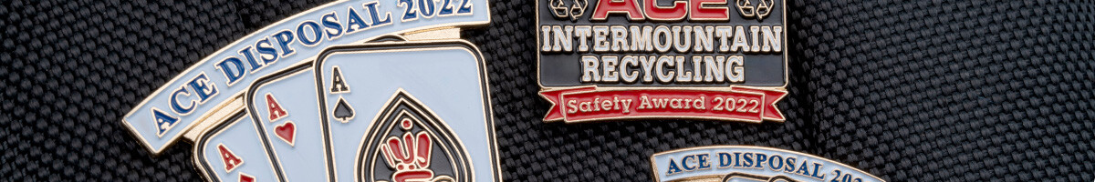 ACE Disposal and ACE Intermountain Recycling safety award pins clipped to a black bag