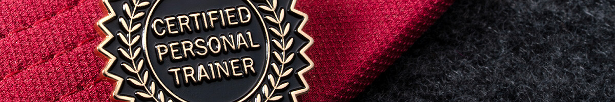 Black and gold Certified Personal Trainer laurel pin on a red cap