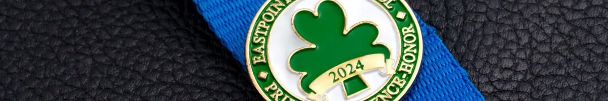 Eastpointe High School 2024 shamrock graduation pin on a blue ribbon