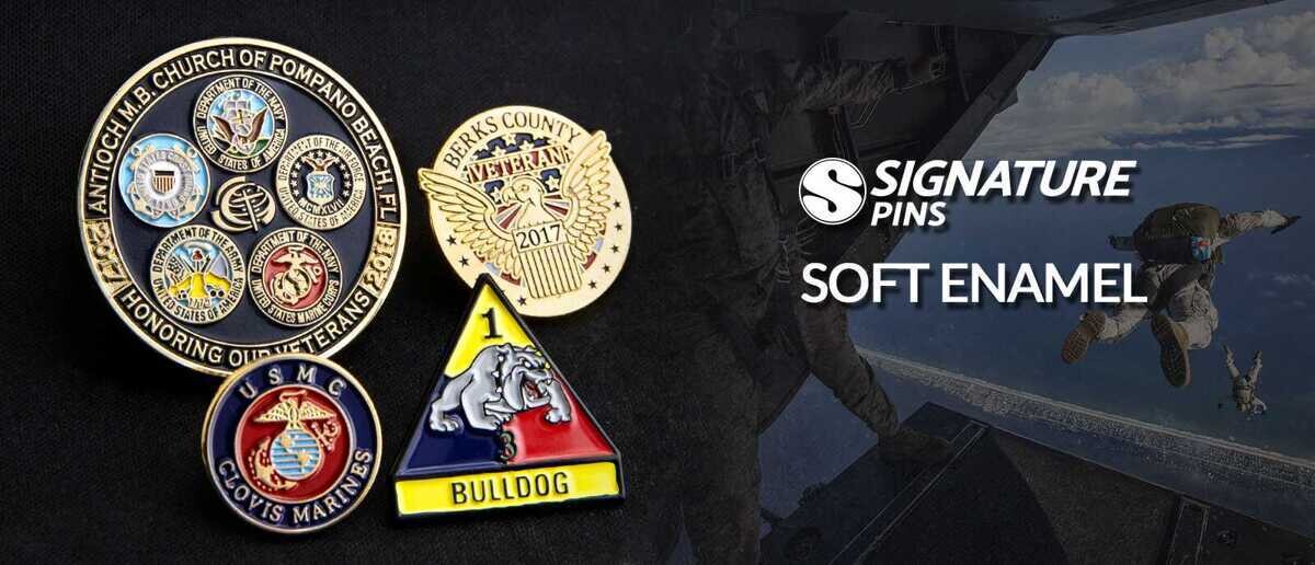 Soft enamel military pins including a veterans pin featuring all service branch seals, Berks County Veterans 2017 eagle pin, USMC Clovis Marines pin, and 1st Armored Division Bulldog unit pin