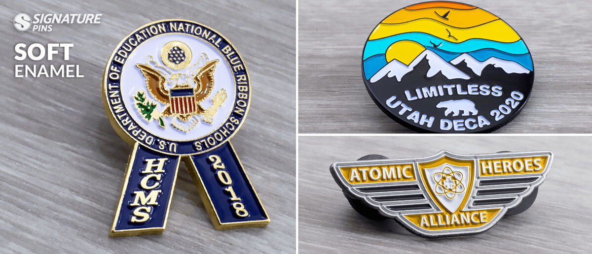 Three soft enamel pins: HCMS National Blue Ribbon School pin with eagle, Limitless Utah DECA 2020 mountain scene pin, and Atomic Heroes Alliance wings pin