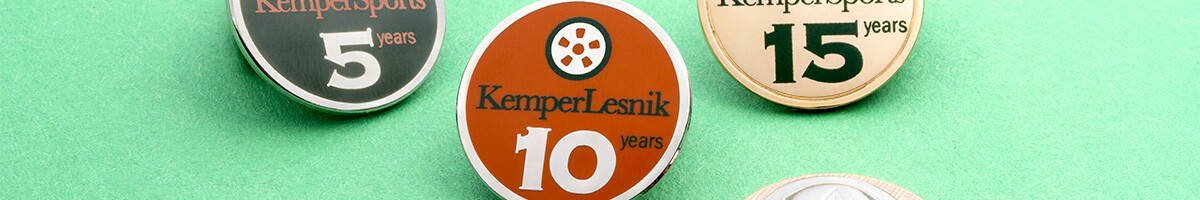 KemperSports and KemperLesnik anniversary pins for 5, 10, and 15 years in silver, orange, and gold
